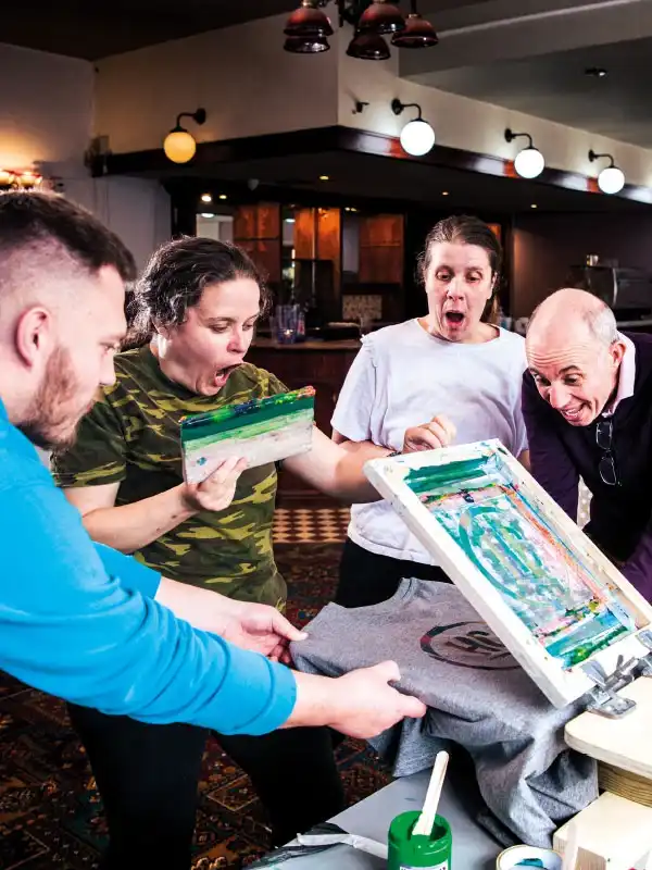 A group of people happily surprised by their screenprinting results