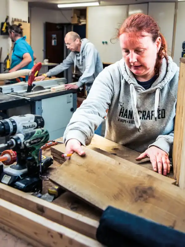 A woman working on a woodwork project in the Handcrafted workshop