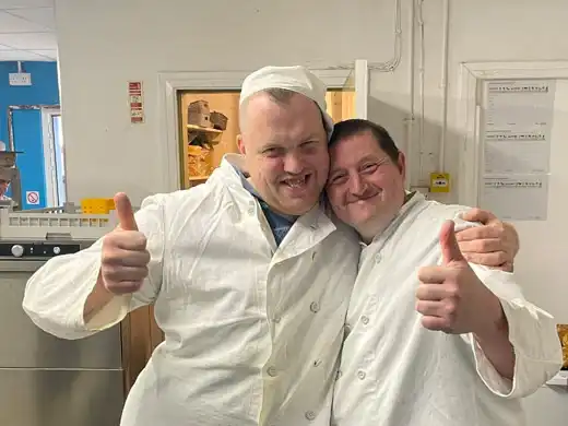 Two Handcrafted kitchen trainees giving the thumbs up