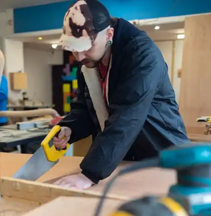 A trainee working on a woodwork project in the Handcrafted workshop